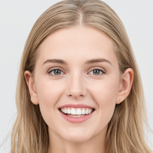 Joyful white young-adult female with long  brown hair and blue eyes