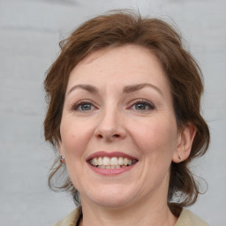 Joyful white adult female with medium  brown hair and grey eyes