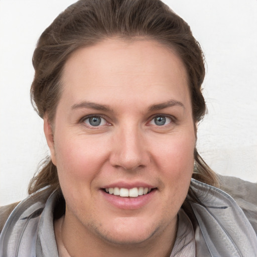 Joyful white young-adult female with short  brown hair and blue eyes