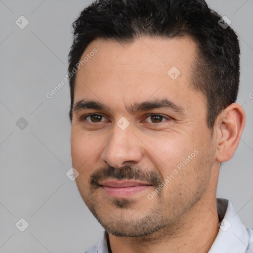 Joyful white adult male with short  black hair and brown eyes