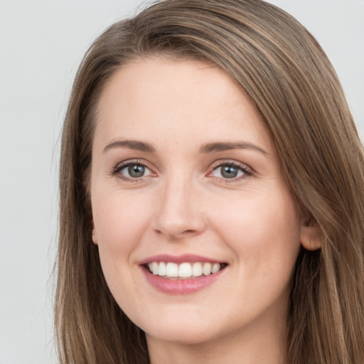 Joyful white young-adult female with long  brown hair and grey eyes