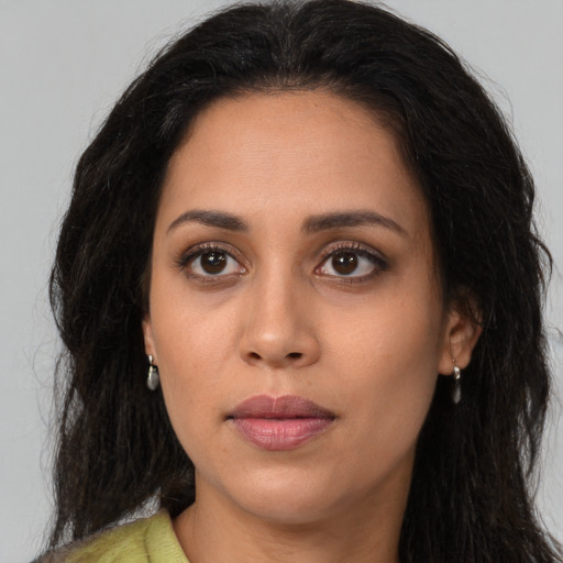 Joyful latino young-adult female with long  brown hair and brown eyes