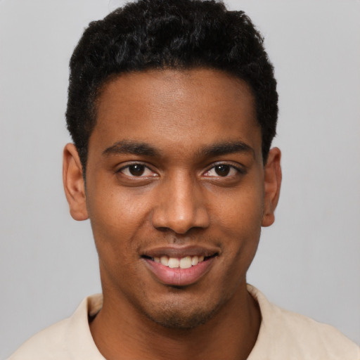 Joyful black young-adult male with short  black hair and brown eyes