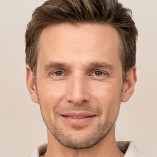 Joyful white adult male with short  brown hair and grey eyes