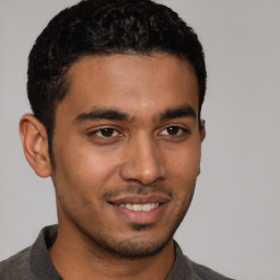 Joyful latino young-adult male with short  black hair and brown eyes