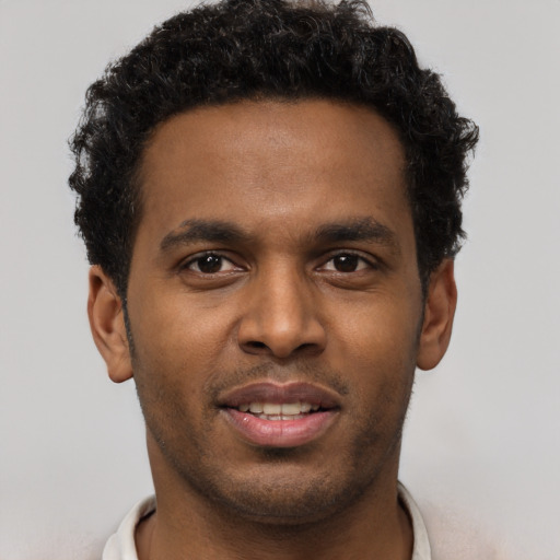 Joyful black young-adult male with short  brown hair and brown eyes