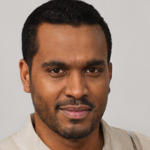Joyful black young-adult male with short  brown hair and brown eyes
