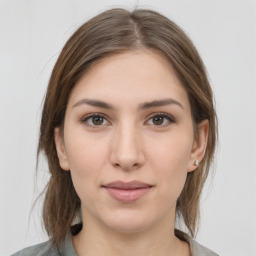 Joyful white young-adult female with medium  brown hair and grey eyes