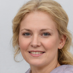 Joyful white young-adult female with medium  brown hair and blue eyes