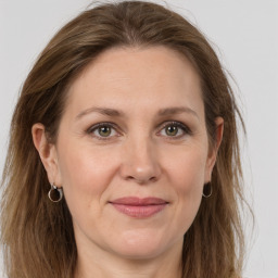 Joyful white adult female with long  brown hair and grey eyes