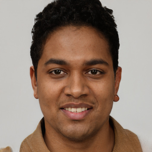 Joyful black young-adult male with short  black hair and brown eyes