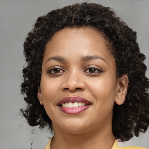 Joyful black young-adult female with medium  brown hair and brown eyes