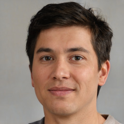 Joyful white young-adult male with short  brown hair and brown eyes