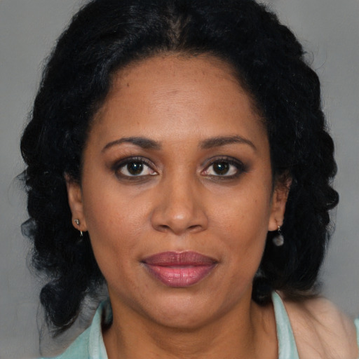 Joyful black adult female with long  black hair and brown eyes