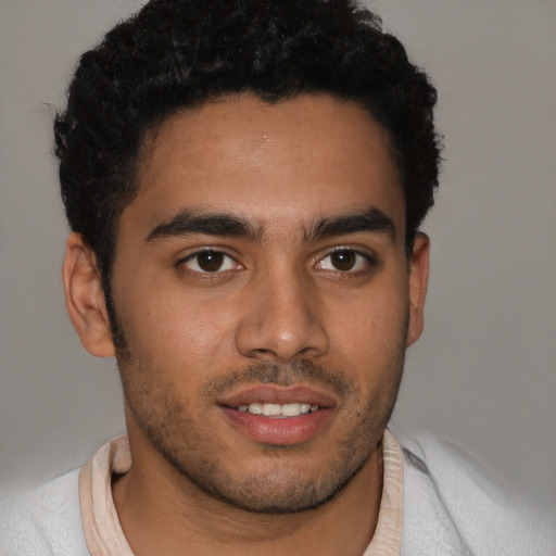 Joyful latino young-adult male with short  brown hair and brown eyes