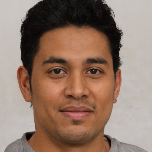 Joyful latino young-adult male with short  brown hair and brown eyes