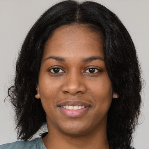 Joyful black young-adult female with long  black hair and brown eyes