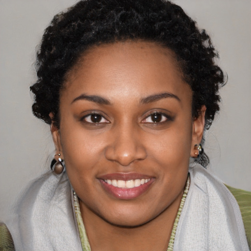 Joyful black young-adult female with long  brown hair and brown eyes