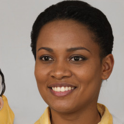 Joyful black young-adult female with short  brown hair and brown eyes