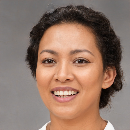 Joyful latino young-adult female with medium  brown hair and brown eyes