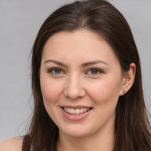 Joyful white young-adult female with long  brown hair and brown eyes