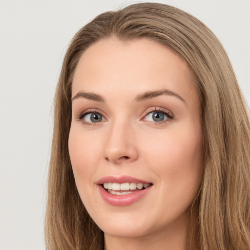 Joyful white young-adult female with long  brown hair and green eyes