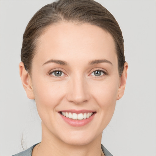 Joyful white young-adult female with short  brown hair and grey eyes