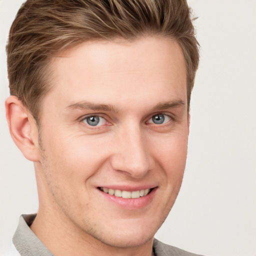 Joyful white young-adult male with short  brown hair and grey eyes