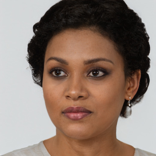 Joyful black young-adult female with short  black hair and brown eyes
