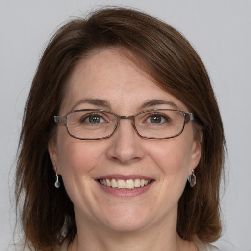 Joyful white adult female with medium  brown hair and blue eyes