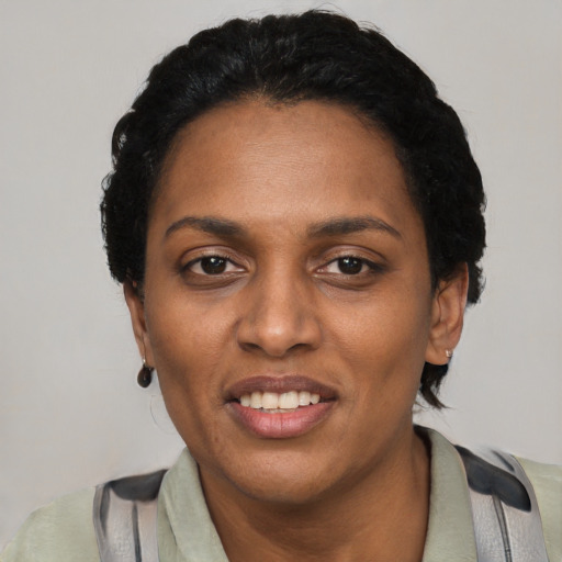 Joyful black young-adult female with short  black hair and brown eyes