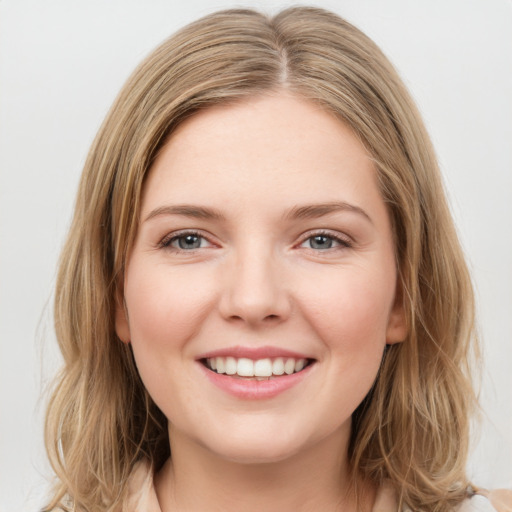 Joyful white young-adult female with long  brown hair and green eyes