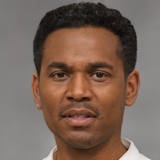 Joyful black young-adult male with short  black hair and brown eyes