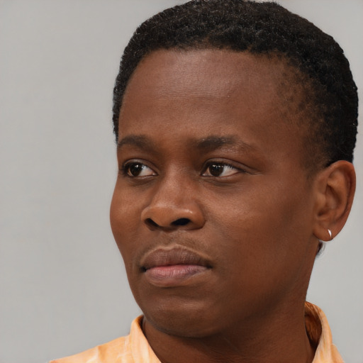 Joyful black young-adult male with short  brown hair and brown eyes