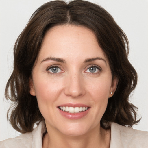 Joyful white young-adult female with medium  brown hair and green eyes