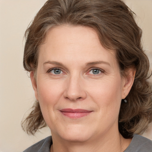 Joyful white adult female with medium  brown hair and grey eyes