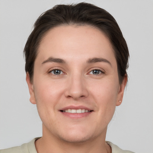 Joyful white young-adult female with short  brown hair and grey eyes