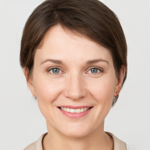 Joyful white young-adult female with short  brown hair and grey eyes