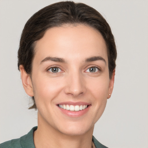 Joyful white young-adult female with short  brown hair and grey eyes