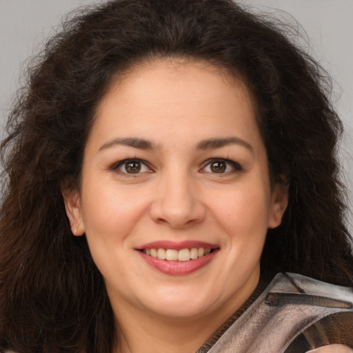Joyful white young-adult female with long  brown hair and brown eyes