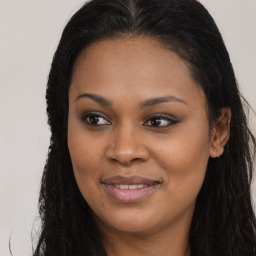 Joyful black young-adult female with long  brown hair and brown eyes