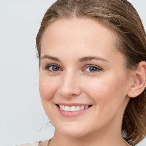 Joyful white young-adult female with long  brown hair and blue eyes