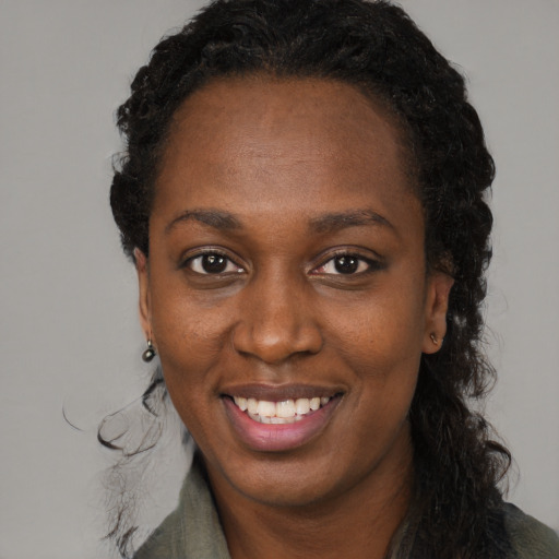 Joyful black adult female with long  black hair and brown eyes