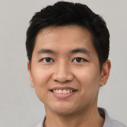 Joyful asian young-adult male with short  black hair and brown eyes