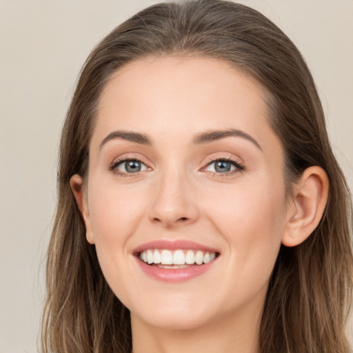 Joyful white young-adult female with long  brown hair and grey eyes