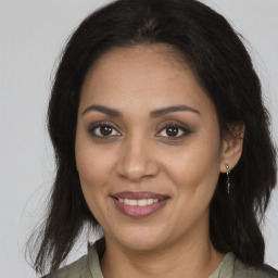 Joyful black young-adult female with long  brown hair and brown eyes