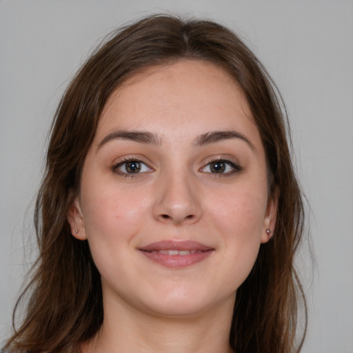 Joyful white young-adult female with long  brown hair and brown eyes