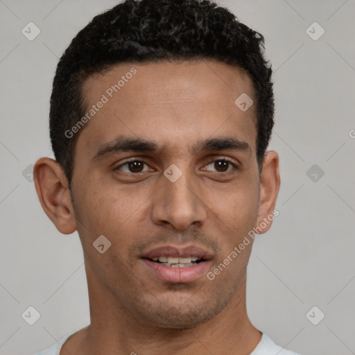 Joyful white young-adult male with short  black hair and brown eyes