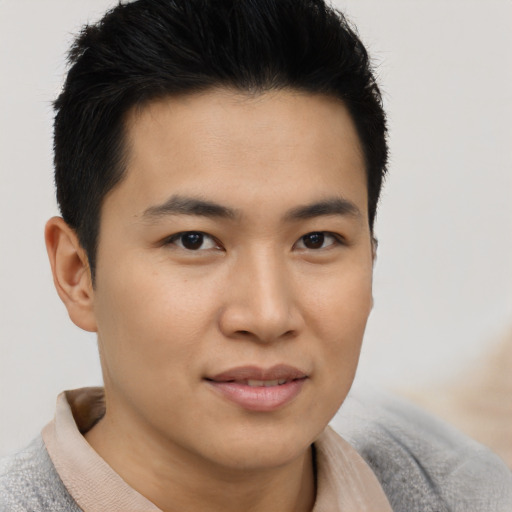 Joyful asian young-adult male with short  brown hair and brown eyes
