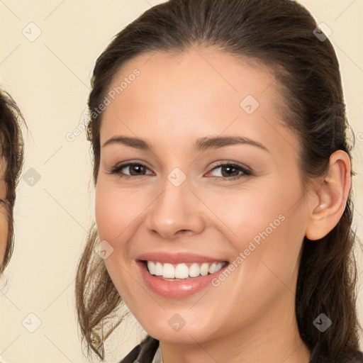 Joyful white young-adult female with long  brown hair and brown eyes